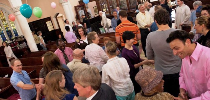 Stock photo of a diverse group of people greeting each other during worship