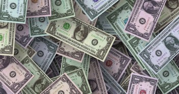 Stock photo of a pile of $1 bills that are multi-colored