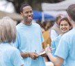 Photo of a group of smiling people holding clipboards at an outside event