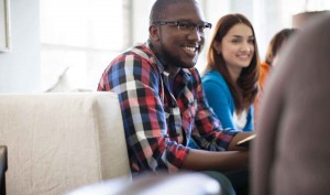 Stock photo of a young African American man and a young white woman in a fellowship group