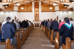 Stock photo of a full sanctuary with a crucifix at the front and center of the altar