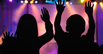 Silhouettes of people worshiping in a contemporary setting