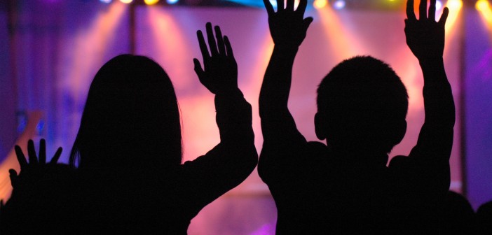 Silhouettes of people worshiping in a contemporary setting