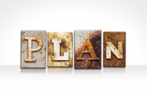 The word "PLAN" written in rusty metal letterpress type