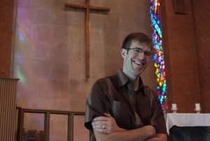 Photo of young pastor smiling in a church