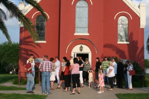 Photo of people gathered in front of a church building