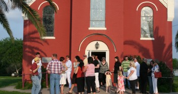 Photo of people gathered in front of a church building