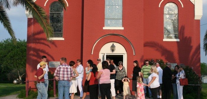 Photo of people gathered in front of a church building