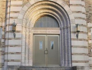 Photo of an arched doorway of a stone seminary building