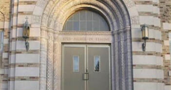 Photo of an arched doorway of a stone seminary building