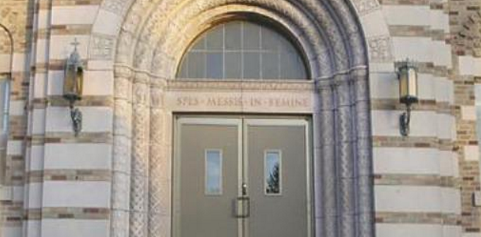 Photo of an arched doorway of a stone seminary building