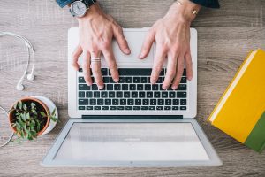 Overhead photo of hands typing on a laptop computer