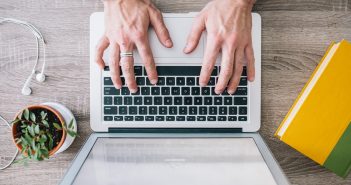 Overhead photo of hands typing on a laptop computer