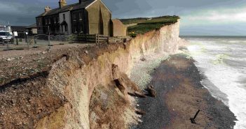 Photo of a building perilously perched on the edge of a crumbling cliff