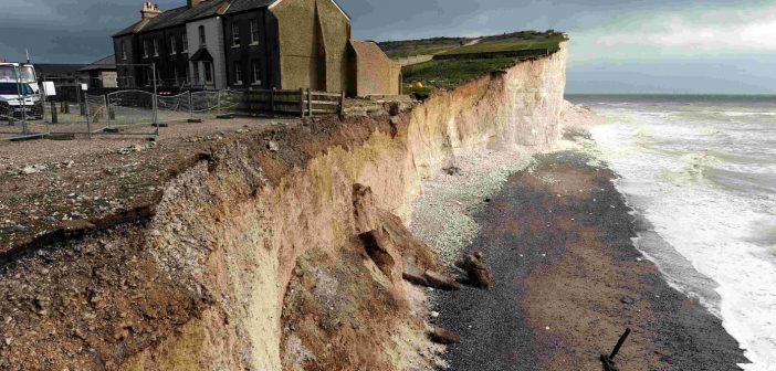 Photo of a building perilously perched on the edge of a crumbling cliff