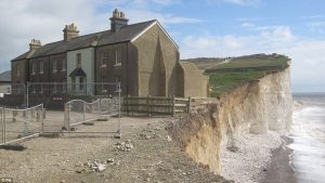 Photo of buildings on the edge of a crumbling cliff