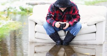 Photo of a man sitting on a sofa in a flood