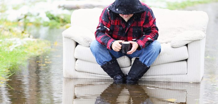 Photo of a man sitting on a sofa in a flood