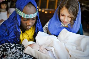 Photo of children playing Mary, Joseph, and baby Jesus in a live nativity scene