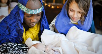 Photo of children playing Mary, Joseph, and baby Jesus in a live nativity scene