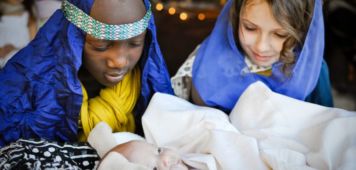 Photo of children playing Mary, Joseph, and baby Jesus in a live nativity scene