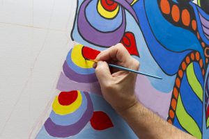 Photograph of someone painting a mural