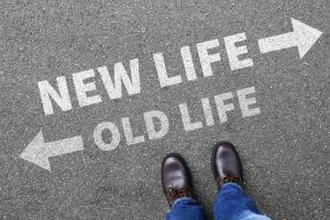 Looking down at directions on concrete. Go one way for new life and go another way for old life