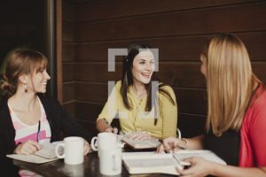 Three women having coffee and forming relationships