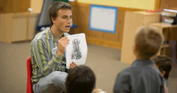 Teacher showing a photo in a book to students in a classroom