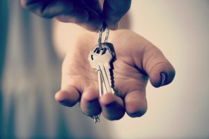 A hand holding a set of keys embarking on one of life's transitions