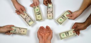 Photo of outstretched hands giving money