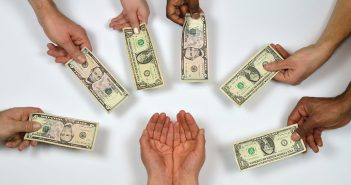 Photo of outstretched hands giving money