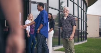 Photo of church greeters shaking hands with visitors