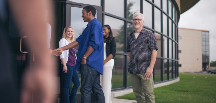 Photo of church greeters shaking hands with visitors