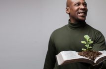 Leadership for Giving Photo of a person holding an open Bible with a seedling sprouting from the pages