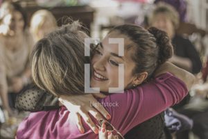 stock photo of two young women hugging.