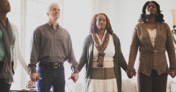 Photo of a diverse group of people holding hands in prayer