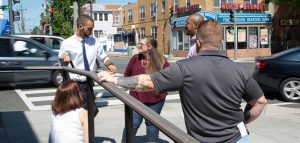 Photo of people having a conversation near a busy intersection