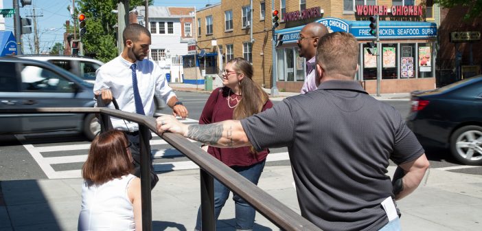 Photo of people having a conversation near a busy intersection