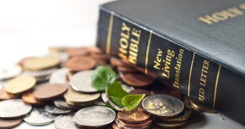 Photo of a Bible and a pile of coins