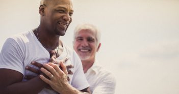 Photo of a pastor baptizing a smiling person in a lake