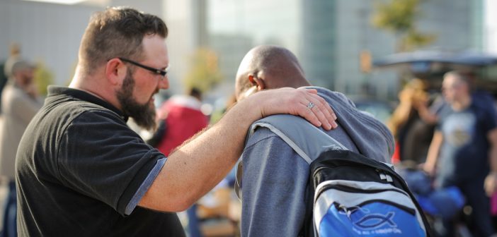 Photo of a concerned person with their hand of a shoulder of another person