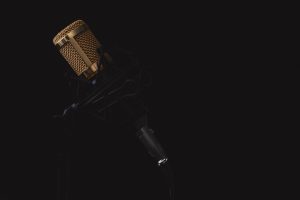 Stock photo of a microphone against a black background.