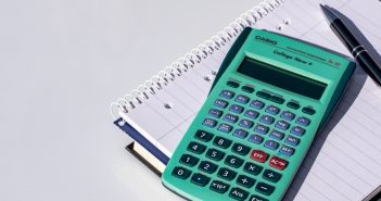 Photo of a calculator, pen, and spiral notebook