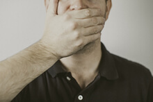 Photo of a person with their hand covering their mouth