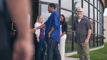 Photo of people being welcomed at the front door of a church