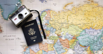 Passport and camera on a map of the world