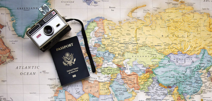 Passport and camera on a map of the world