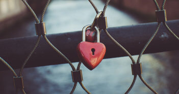 Rusty heart-shaped lock on a closed gate