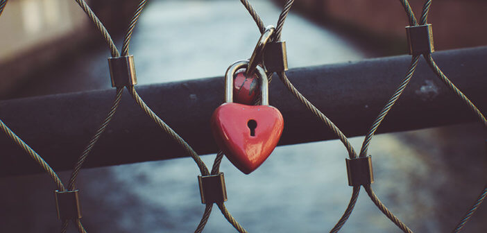 Rusty heart-shaped lock on a closed gate